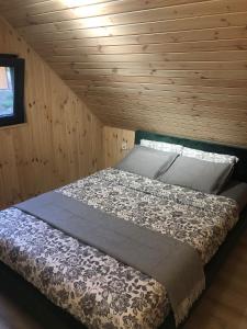 łóżko w pokoju z drewnianą ścianą w obiekcie Domki Trzy w mieście Krzywonoga