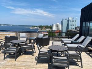 a patio with tables and chairs and a view of the water at The Simon Hotel Sydney in Sydney