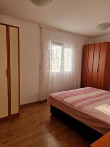 a bedroom with a bed and a window at Guest House Ivana in Tivat