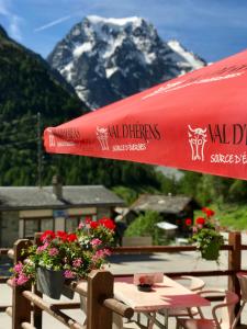 a red umbrella sitting on top of a table with flowers at Hotel du Pigne in Arolla