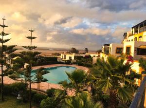 a view of a resort with a swimming pool at Maison Oualidia Vue sur Mer-Jardins de la Lagune in Oualidia