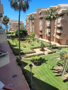 a park in front of a building with palm trees at CasaBel - Playa in Torrox Costa