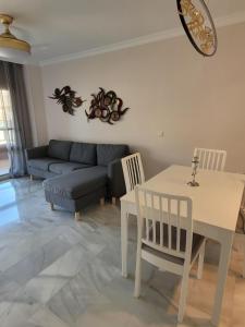 a living room with a couch and a table and chairs at CasaBel - Playa in Torrox Costa