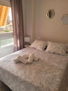 a bed with two towels on it with a window at CasaBel - Playa in Torrox Costa +16 photos
