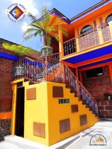 a colorful house with a staircase and a palm tree at Posada Arny in Tepotzotlán