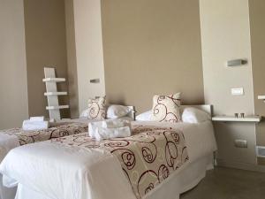 two beds in a room with white at Appartamento I Boschetti in Magliano Alpi