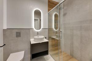 łazienka z umywalką i lustrem w obiekcie Baltic Lagoon - Okrzei Residence w mieście Sopot +15 zdjęć