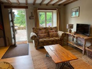 een woonkamer met een bank en een salontafel bij Pond Cottage in Rosedale Abbey