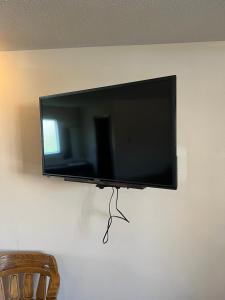 a flat screen tv hanging on a wall at Barnesville Motel 