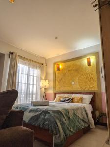 um quarto com uma cama com uma grande pintura na parede em Home and Away Cozy Studio Apartment number 407 em Nairobi