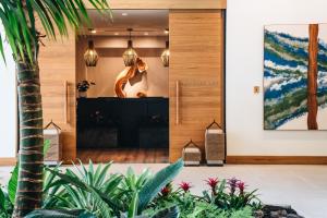 a woman standing in a lobby with a fireplace at Mauna Lani, Auberge Resorts Collection in Waikoloa