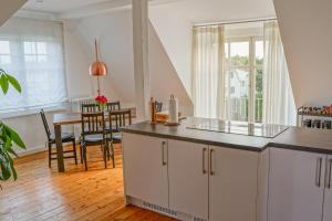 eine Küche mit weißen Schränken, einem Tisch und einem Fenster in der Unterkunft Traumhaft wohnen in Jugendstilvilla in Speyer