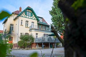 ein großes weißes Haus mit grünem Dach in der Unterkunft Traumhaft wohnen in Jugendstilvilla in Speyer
