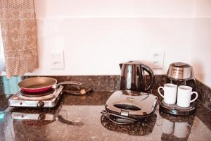 a kitchen counter with a coffee maker and coffee cups at CHALÉS SÓ COISAS BOAS in Ouro Preto