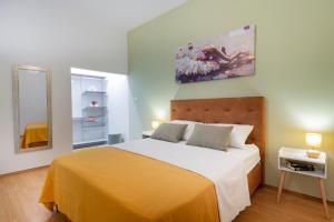 um quarto com uma cama grande e um cobertor amarelo em Apartment Two Oranges em Dubrovnik