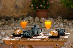 uma mesa com dois copos de sumo de laranja e croissants em Apartment Two Oranges em Dubrovnik
