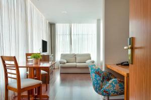 sala de estar con mesa y sofá en Hotel Petropolis Inn, en Petrópolis