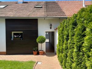 uma casa branca com uma porta preta e plantas em SG chalupa MLÁZOVICE 1 se soukromým wellness v ceně em Mlázovice