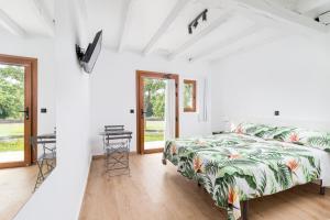 een witte slaapkamer met een bed en een tafel bij BENEDICTA FAMILY ROOMS in Suances