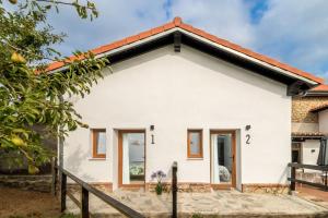 uma casa branca com um telhado vermelho em BENEDICTA FAMILY ROOMS em Suances