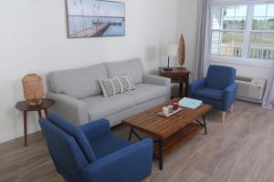 a living room with a couch and two chairs and a table at Gateway to Greenwich Suites in Saint Peters