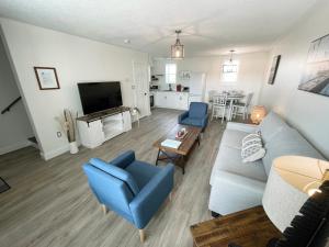 sala de estar con sofá azul y sillas azules en Gateway to Greenwich Suites, en Saint Peters