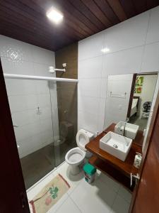 a bathroom with a toilet and a sink at Casa Patio em Areia in Areia