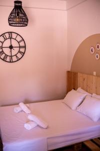 łóżko z dwoma ręcznikami i zegarem na ścianie w obiekcie Wilson & Andrew House - Boho Bliss w mieście (( Sgoúrna ))