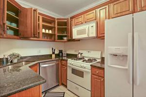 - une cuisine avec des appareils blancs et des armoires en bois dans l'établissement Alluring 2BR Apt in Old Irving Park with Laundry - Cullom D3, à Chicago