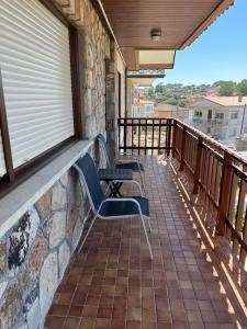eine Veranda mit 2 Bänken auf einem Balkon in der Unterkunft Patos Beach III - Olas in Nigrán