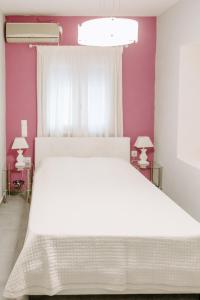 una camera con letto bianco e pareti viola di Pine trees 55 ad Atene