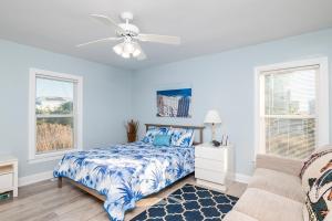 a bedroom with a bed and a ceiling fan at SeaSide by Oak Island Accommodations in Oak Island