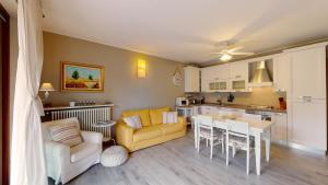 een woonkamer met een gele bank en een keuken bij Appartamento al Moro in Reno Di Leggiuno