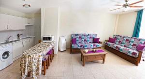 cocina y sala de estar con mesa y sillas en Sunset Apartment, Puerto Santiago, en Puerto de Santiago