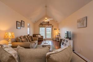 Una sala de estar con sofás y un televisor. en Seashell Cottage by Oak Island Accommodations, en Oak Island