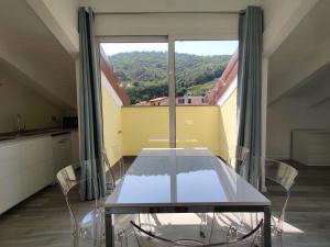 a table and chairs in a room with a large window at Sotto il Cielo in Finale Ligure