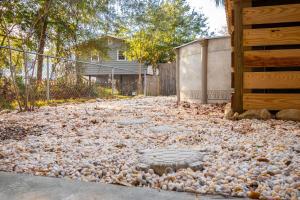 a driveway covered with rocks and a sidewalk at Woodlands Wonder by Oak Island Accommodations in Oak Island