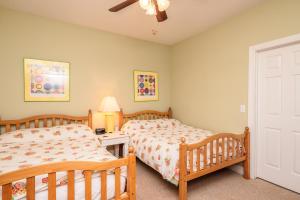 a bedroom with two twin beds and a ceiling fan at Woodlands Wonder by Oak Island Accommodations in Oak Island