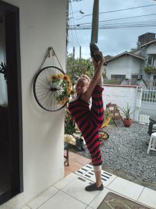 Una mujer está haciendo una parada de manos con una bicicleta en la pared en Hostel Cidade das Flores 2, en Joinville