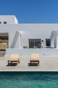 twee stoelen op een terras naast het water bij Muro Suites in Ornos