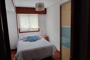 ein kleines Schlafzimmer mit einem Bett und einem Fenster in der Unterkunft Acogedor apartamento en Pontedeume in Puentedeume