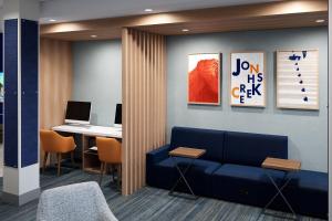 een lobby met een blauwe bank en een bureau met een laptop bij HOLIDAY INN EXPRESS & SUITES DALLAS PLANO NORTH, an IHG Hotel in Plano