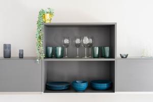 a shelf with wine glasses and plates on it at New Central Studio with Parking in Ljubljana