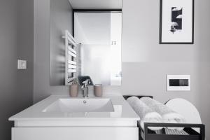 a white bathroom with a sink and a mirror at New Central Studios with parking in Ljubljana +45 photos