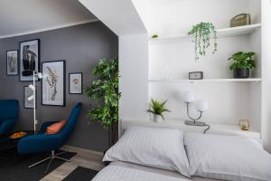 a bedroom with a bed and a blue chair at New Central Studios with parking in Ljubljana