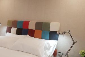 uma cama com uma cabeceira colorida ao lado de um candeeiro em Centro Zaragoza, con parking incluido em Zaragoza