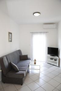 a living room with a couch and a tv at Apartments Lepur in Vodice
