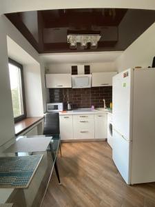 a kitchen with a white refrigerator and a table at 1-room Studio center in Cherkasy