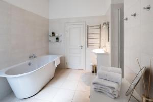 a white bathroom with a tub and a sink at Old Riga Modern and Spacious 2 bedroom Apartment in Rīga +19 photos