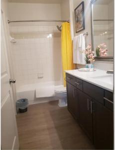 a bathroom with a white tub and a toilet and a sink at Cozy 1bd in the heart of downtown Dallas!(w/parking) in Dallas